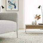 Modern living room with a gray sofa, wooden coffee table, and abstract art on the wall.
