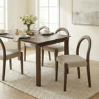 Dining room with a wooden table and chairs on a light rug.
