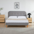 Gray upholstered bed with white bedding in a bedroom setting.