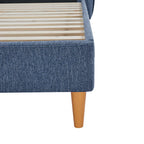 Blue upholstered bed frame with wooden legs on a white background
