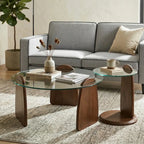 Modern living room with a gray sofa, glass coffee table, and wooden side table.