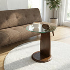 Round wooden side table with glass top in a living room setting