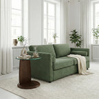 Green sofa in a bright living room with a small table and decorative items.
